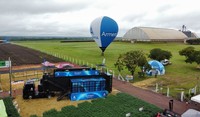 Imagem aérea do truck, balão e estande do Armero Experience em feira agropecuária.